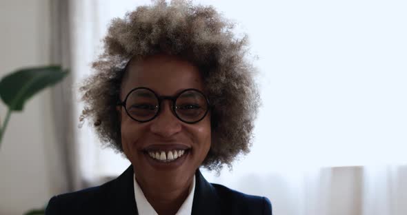 African young woman smiling on camera inside modern office