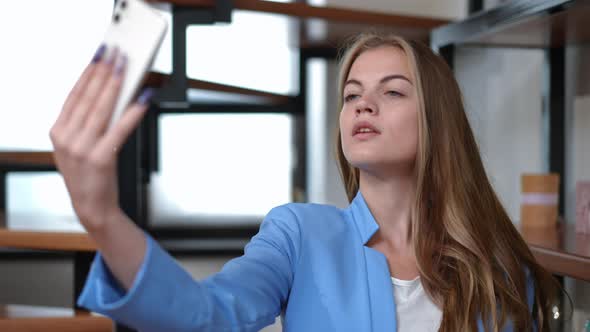 Elegant Confident Young Beautiful Woman Taking Selfie on Smartphone Standing Indoors at Home
