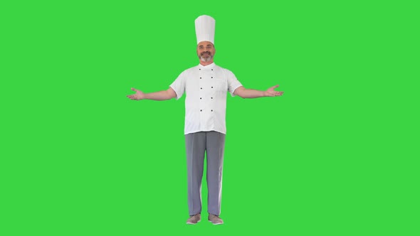 Professional Chef Man Making Welcome Gesture To Camera on a Green Screen Chroma Key