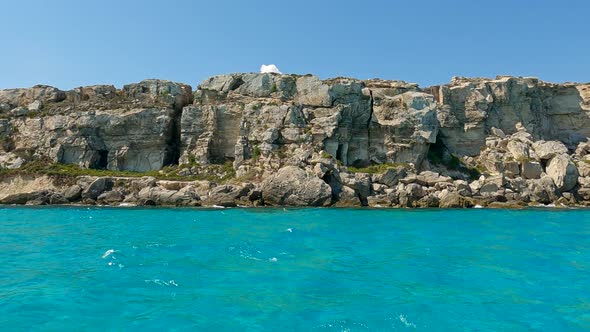 Picturesque Cala Rossa cove at Favignana island in Sicily, Italy. Slow motion water surface pov