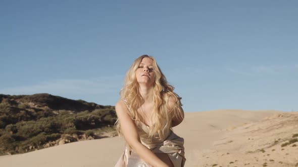 Blond Woman Dancing In Gold On Beach