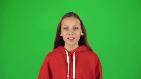 Portrait of Girl Smiling Looking at Camera on Green Background.