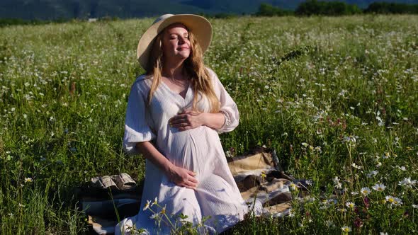 Young Beautiful Pregnant Woman Enjoy Chamomile Field