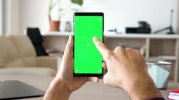 Man Hand Scrolling Down and Right on a Modern Smartphone with Green Screen Chroma Mock Up