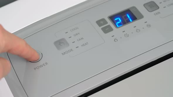 Person Presses the Start Button with Finger on a Mobile Air Conditioner for Heating and Coolingthe
