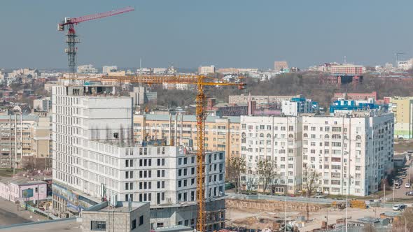 Construction Site with Lots of Yellow Cranes Next to the Road Timelapse Aerial View