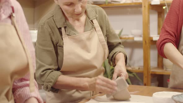 Three Caucasian Women Making Earthenware Bowls in Pottery Workshop