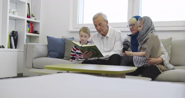 Muslim Family Generations Grandparents Reading Quran with Grandchildren at Home