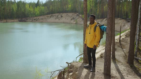 Back View of One Black Man Looking on Mountain and Lake