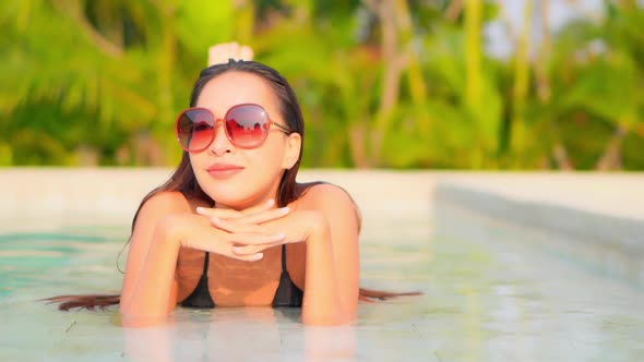 Young asian woman enjoy around outdoor swimming pool for leisure