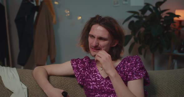 Close Up of Sad Drunk Man with a Dress Sitting on Sofa After Brake Up and Eating Chocolate