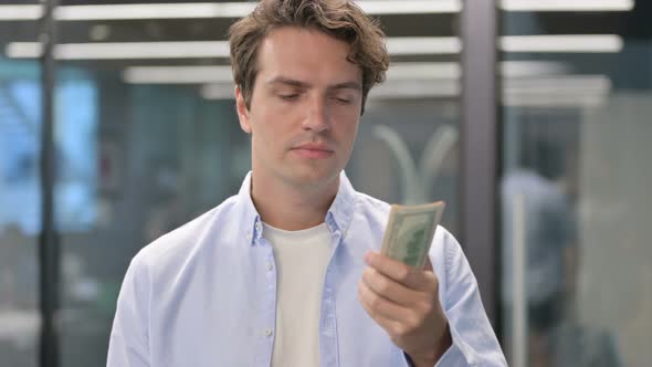 Portrait of Man Feeling Disappointed While Counting Dollars