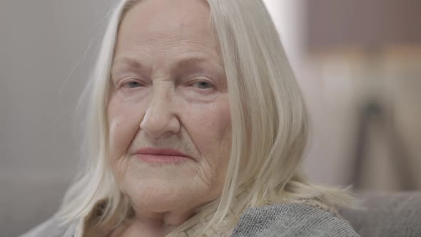 Headshot Portrait of Sad Lonely Old Caucasian Woman with Grey Hair Looking at Camera with Upset