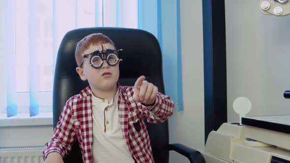 A Redhaired Boy with Braces in a Checkered Red and White Shirt in the Ophthalmologist's Office at