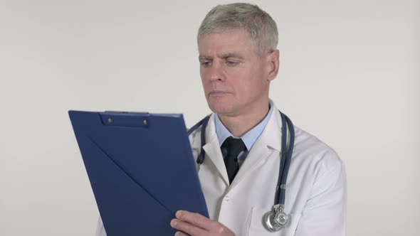 Senior Doctor Reading Medical Documents, White Background