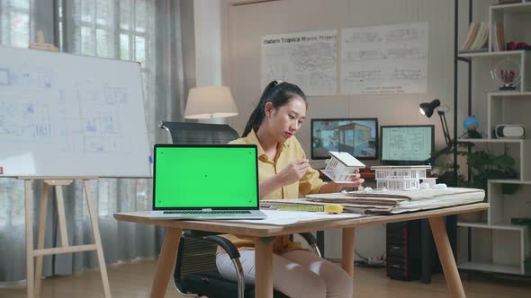 Laptop Green Screen With Asian Woman Engineer Making Paper Model Of House At The Office