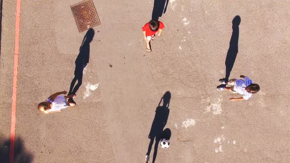 Schoolboys playing football in playground