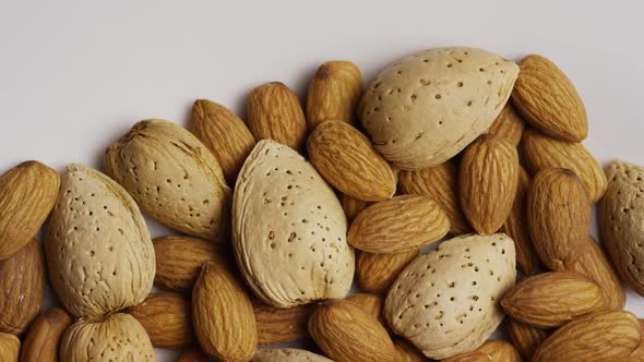 Cinematic, rotating shot of almonds on a white surface 