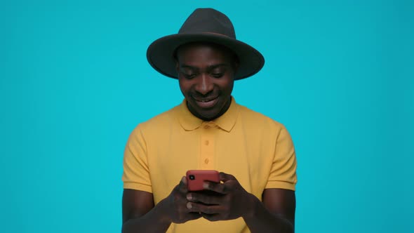 African Male Hipster Typing Messages on Smartphone
