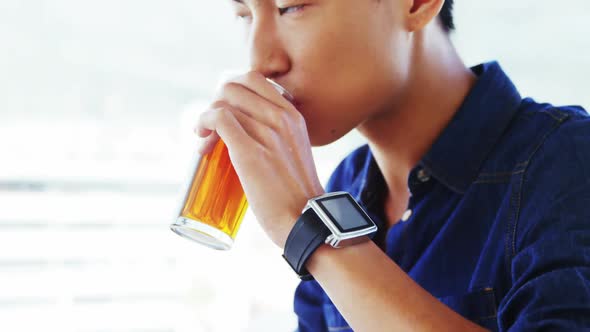 man sipping drink wearing smartwatch