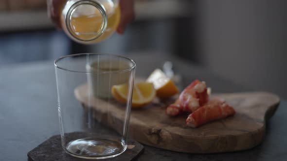 Pour Ginger Beer in Tumbler Glass with Crab Legs on Background