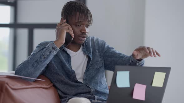 Young Busy Man Hanging Up Phone Closing Laptop with Dissatisfied Facial Expression