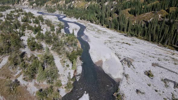 A valley with a narrow blue river meandering through it. Aerial wide angle shot