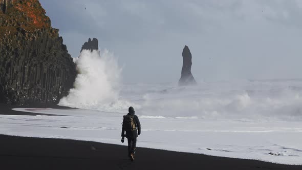 Photographer On Black Sand Beach Watching Rough Sea