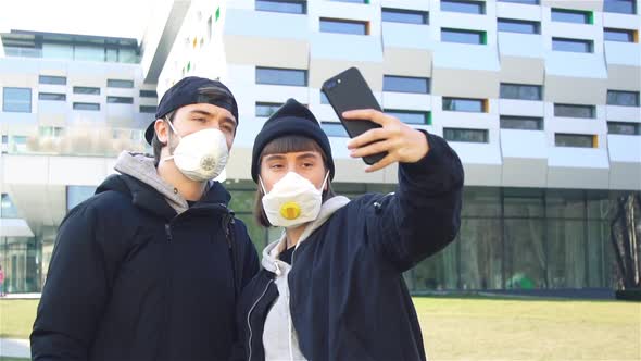 Stylish Couple Making Selfies on Street in Respiratory Mask and Showing Peace