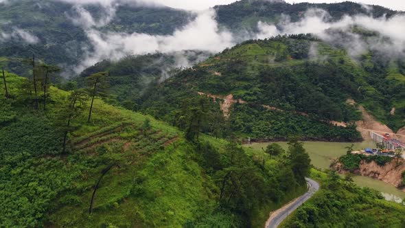 Aerial View of Scenic Hills with Forest Lush Greenery Lake and Foggy Mountains