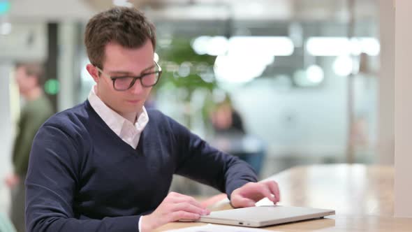 Young Businessman Closing Laptop and Going Away