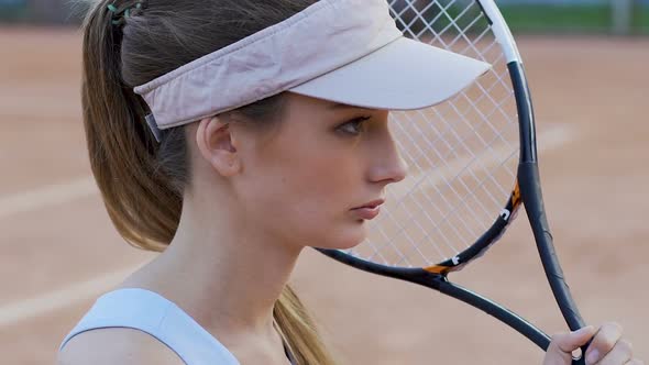 Young Woman Tennis Player Holding Racket, Competitive Spirit, Motivation to Win