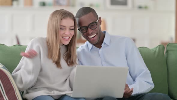 Online Video Chat on Laptop By Mixed Race Couple Home