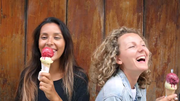 Laughing Girls Eating Ice Cream Against Wooden Wall