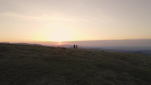 Aerial View of Group of Hikers Sitting on the Mountain Top and Watching the Sunset