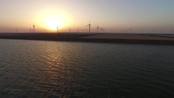 Wind Turbines Alternative Bioenergy on the Background of a Golden Sunset. Aerial Survey