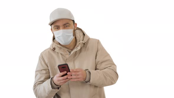 Young Casual Man Walking Making a Call Wearing Warm Clothes and Protective Mask on White Background.