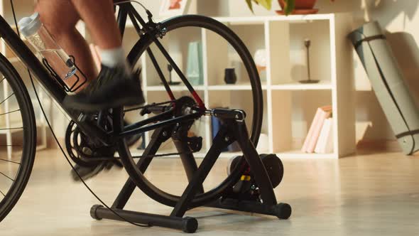 Legs of Sportsman Riding Bicycle Home Gym