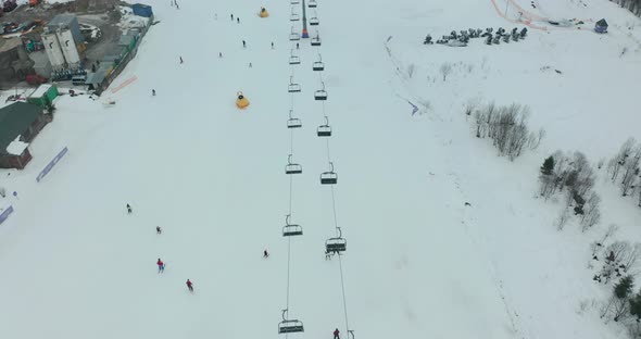 Aerial View: Ski Resort, Slope and Chair Lift. Cableway Lifts Skiers To the Mountain Hill. Winter