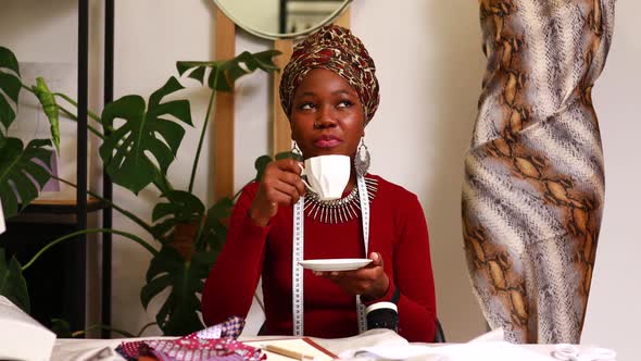 Tanzanian Woman with Snake Print Turban Over Hear Working in Fashion House