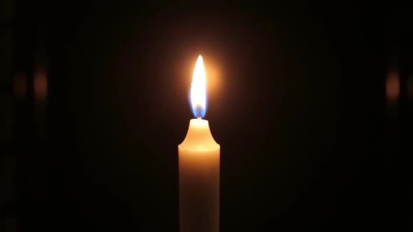 Close-up Flame of Burning Candle on Black Background