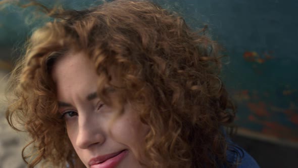 Girl Looking Camera Blowing Curly Hair From Face Close Up