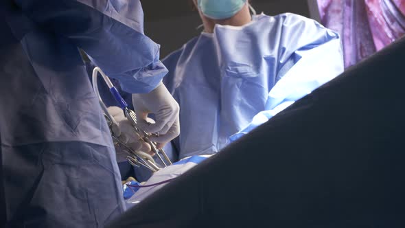 Surgeons working during surgery, close up on hands and instruments.