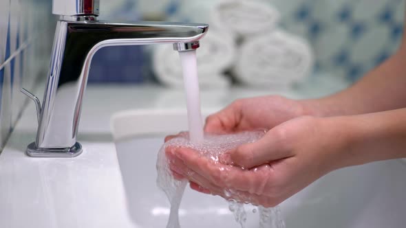 Water Tap with Running Water and Teenage Hands. Washing Hands Under Water Tap or Faucet Without Soap