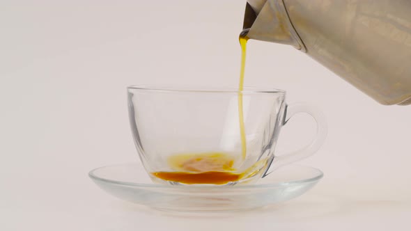 Pouring tea into the cup.