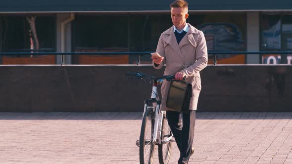 Businessman with mobile phone going near bicycle