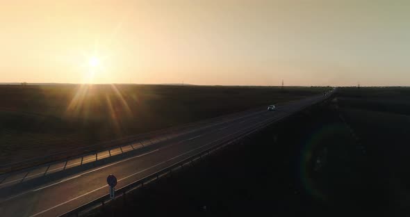 Police Car With Flashes Of Beacons Driving On The Highway At Sunset 01