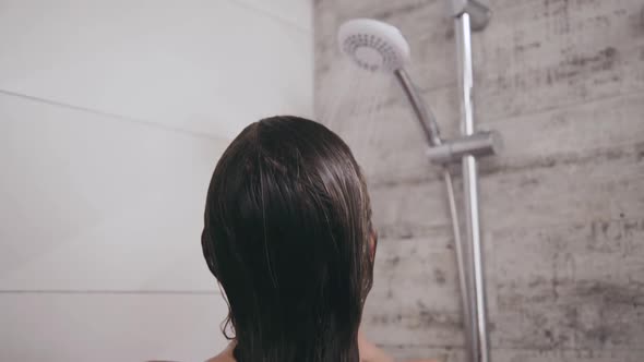 Back Look of Woman Cleansing Body Under Shower