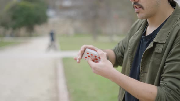 Close Up Side Shot of a Male Magician Shuffling with Cards Before Doing Tricks at Daytime with the