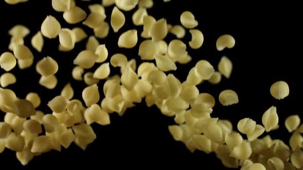 Raw Shells Pasta Flies. Pile of Italian Macaroni Before Preparation Bouncing and Falling Down